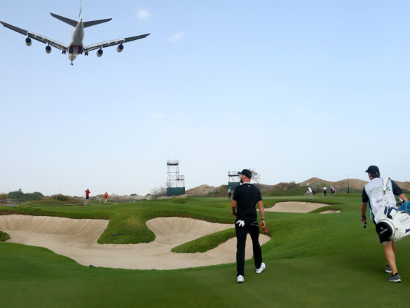 MUSCAT, OMAN - MARCH 01: Chris Wood of England and his caddie walk along the 14th hole as a airplane passes overhead during day two of the Oman Open at Al Mouj Golf Complex on March 01, 2019 in Muscat, Oman. (Photo by Warren Little/Getty Images)